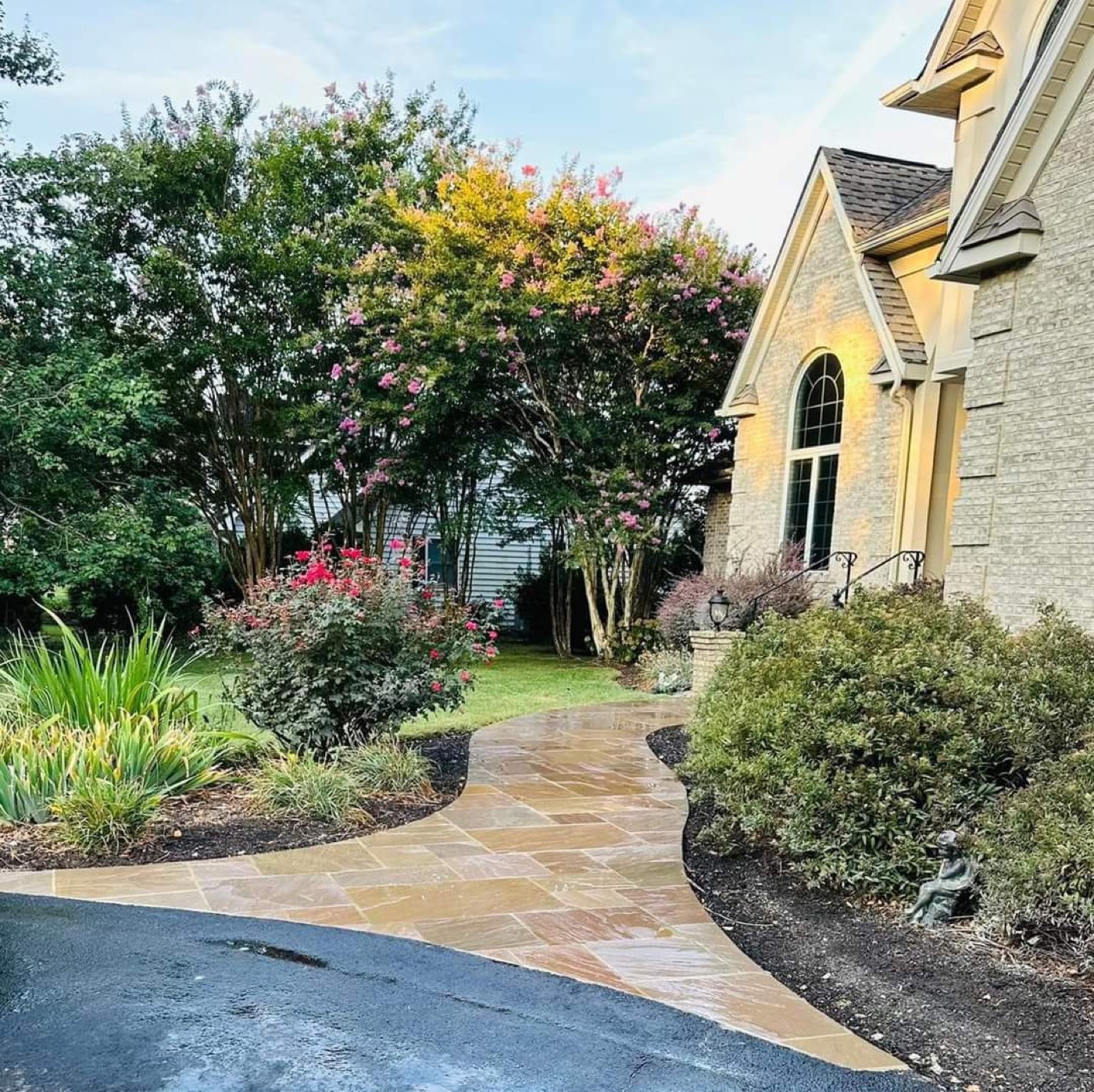 Curved natural stone walkway through front landscaping