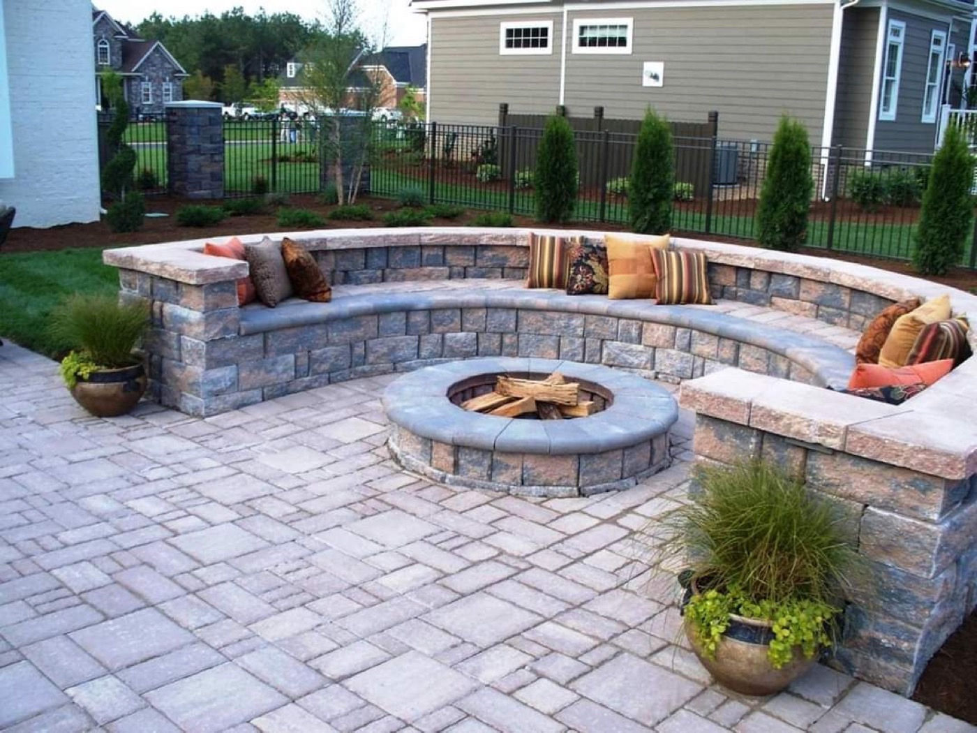 Curved stone seating wall around a fire pit patio