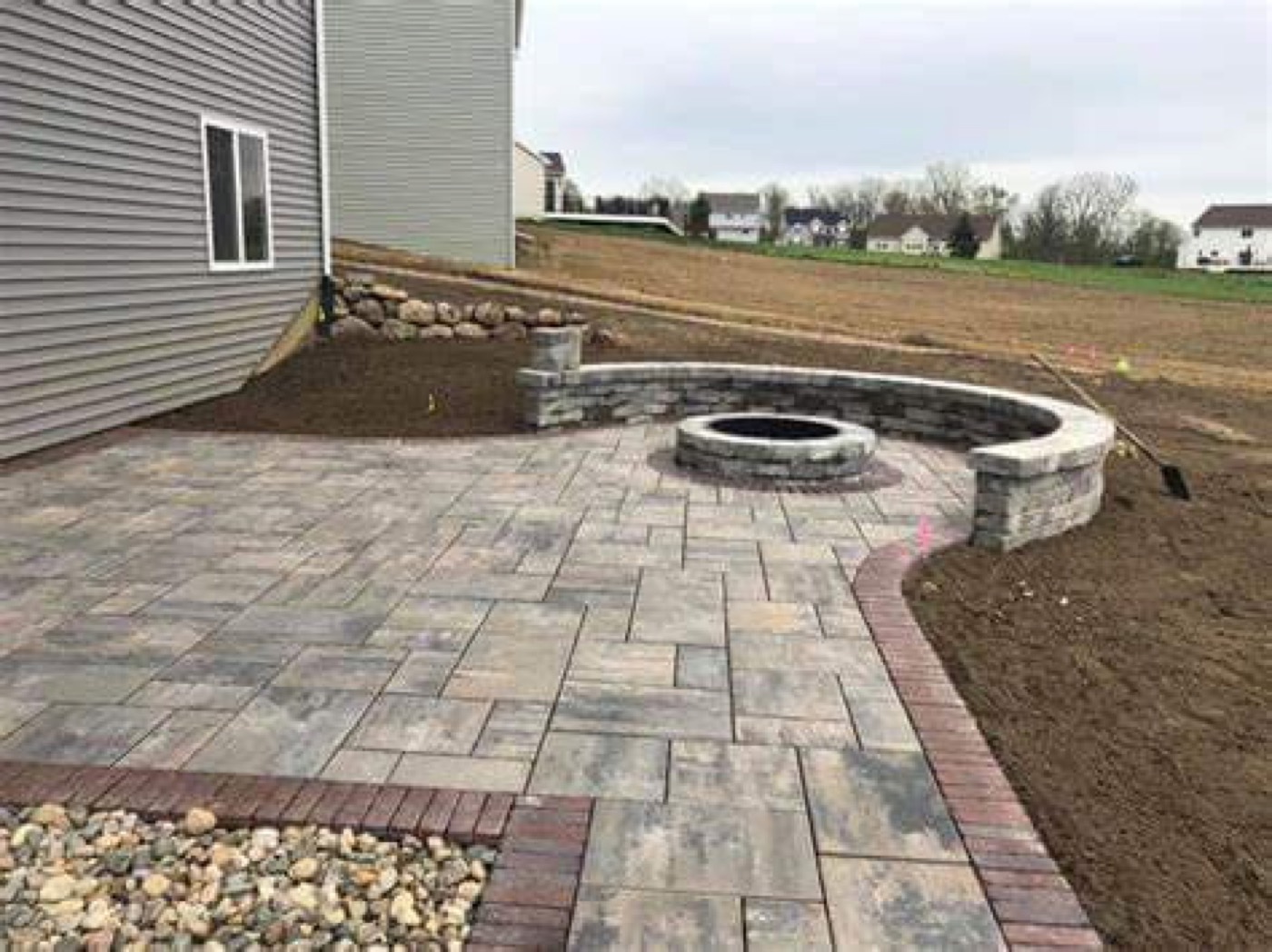 Paver patio with fire pit and curved stone wall