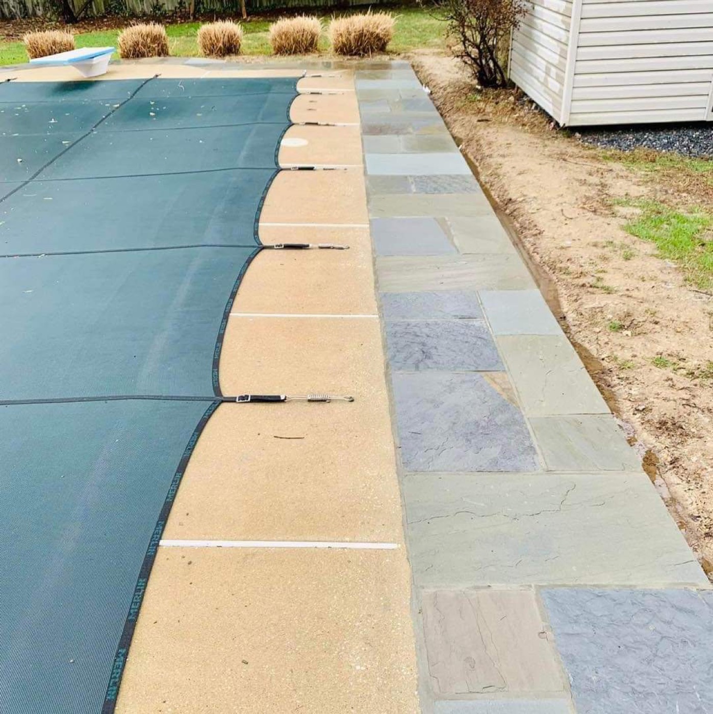 Pool coping and border paver work beside covered pool