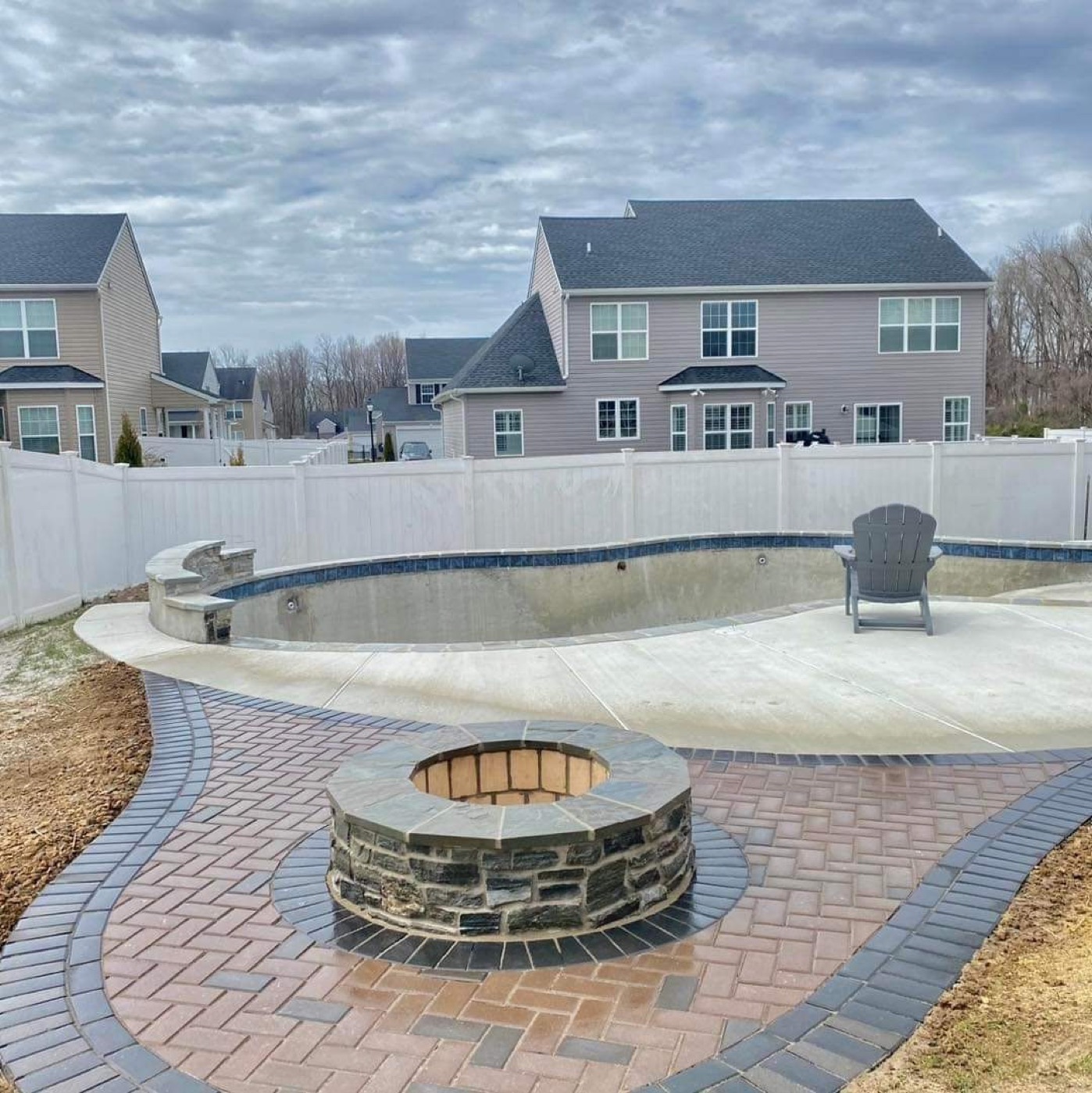 Poolside round fire pit with paver border