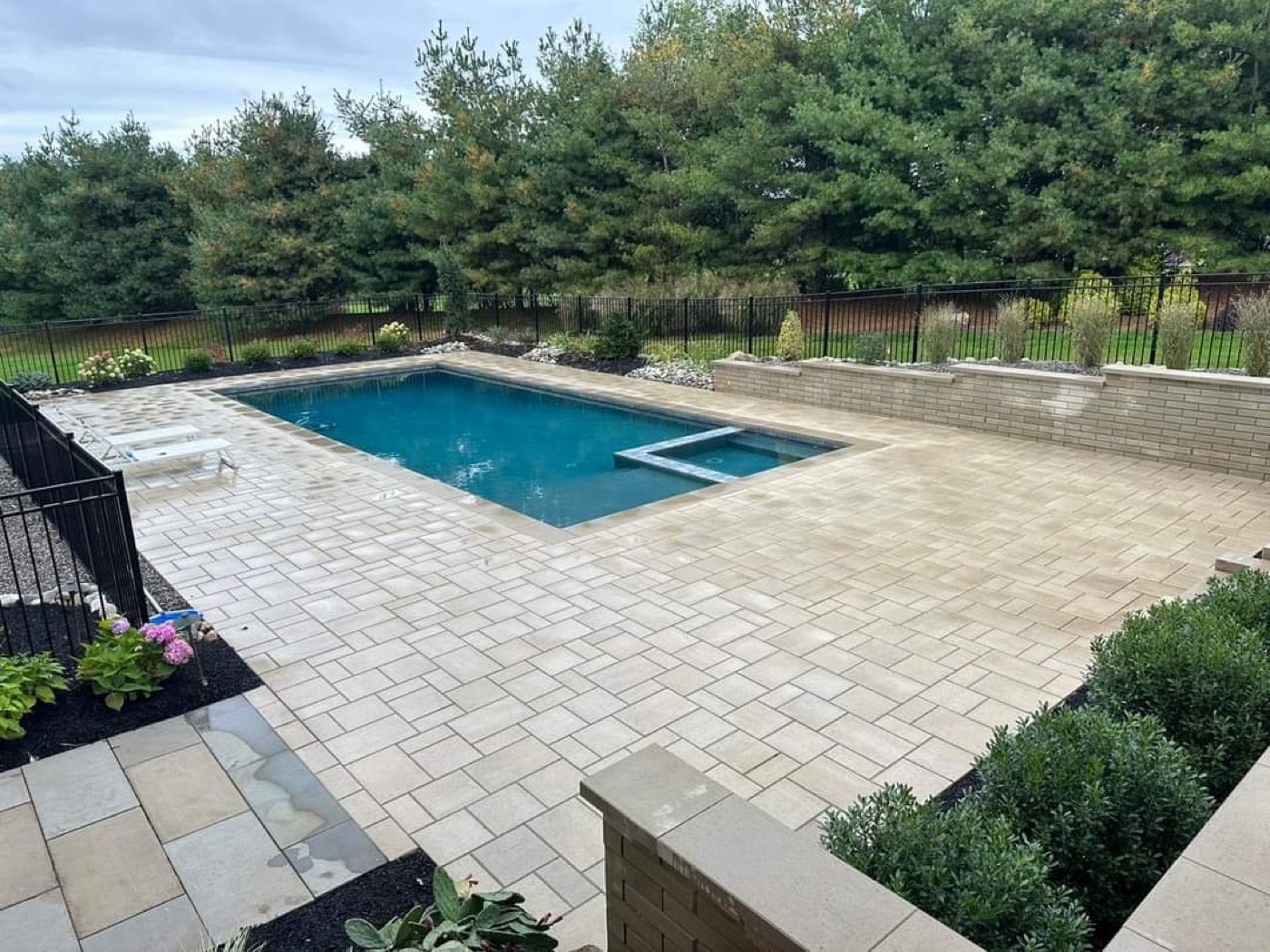 Pool with completed paver deck and retaining wall