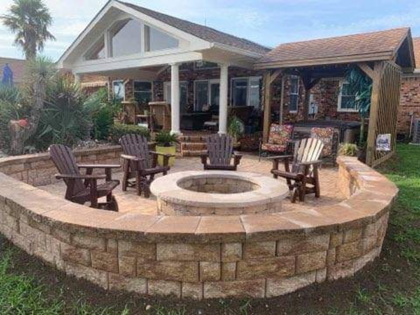 Round patio with fire pit and curved seating wall