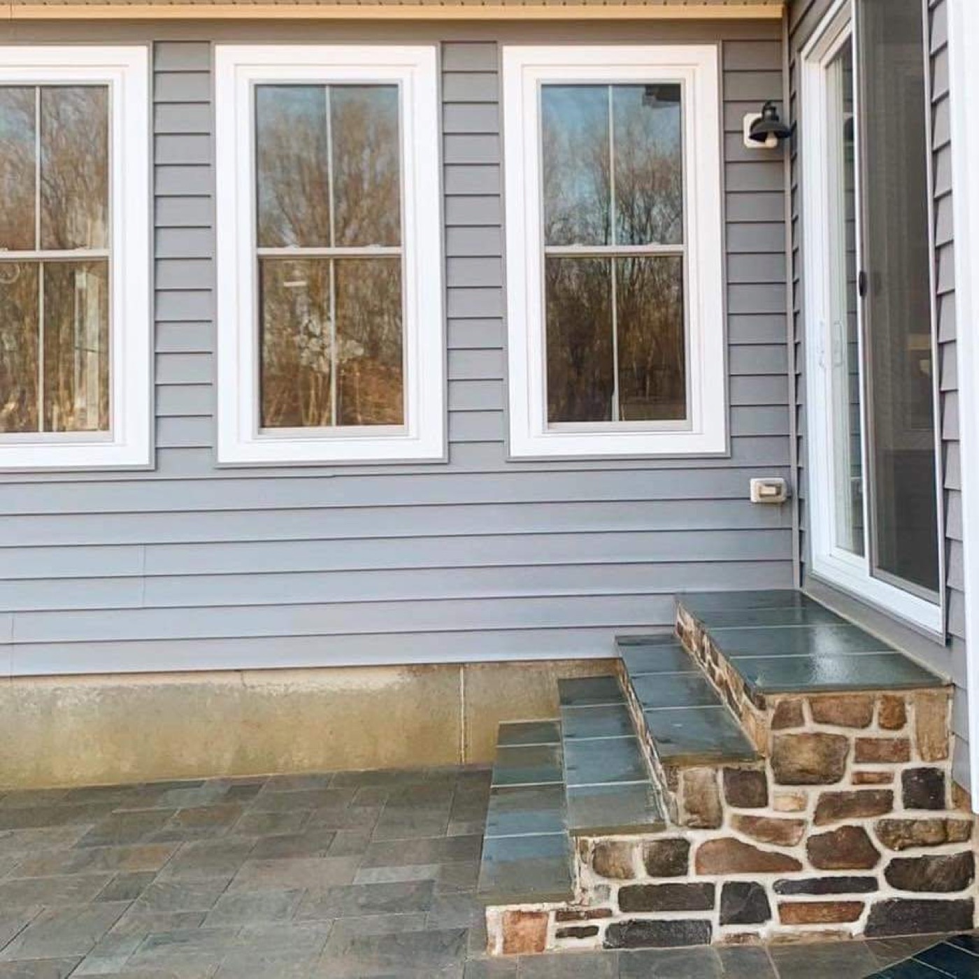 Stone entry patio and steps at brick home