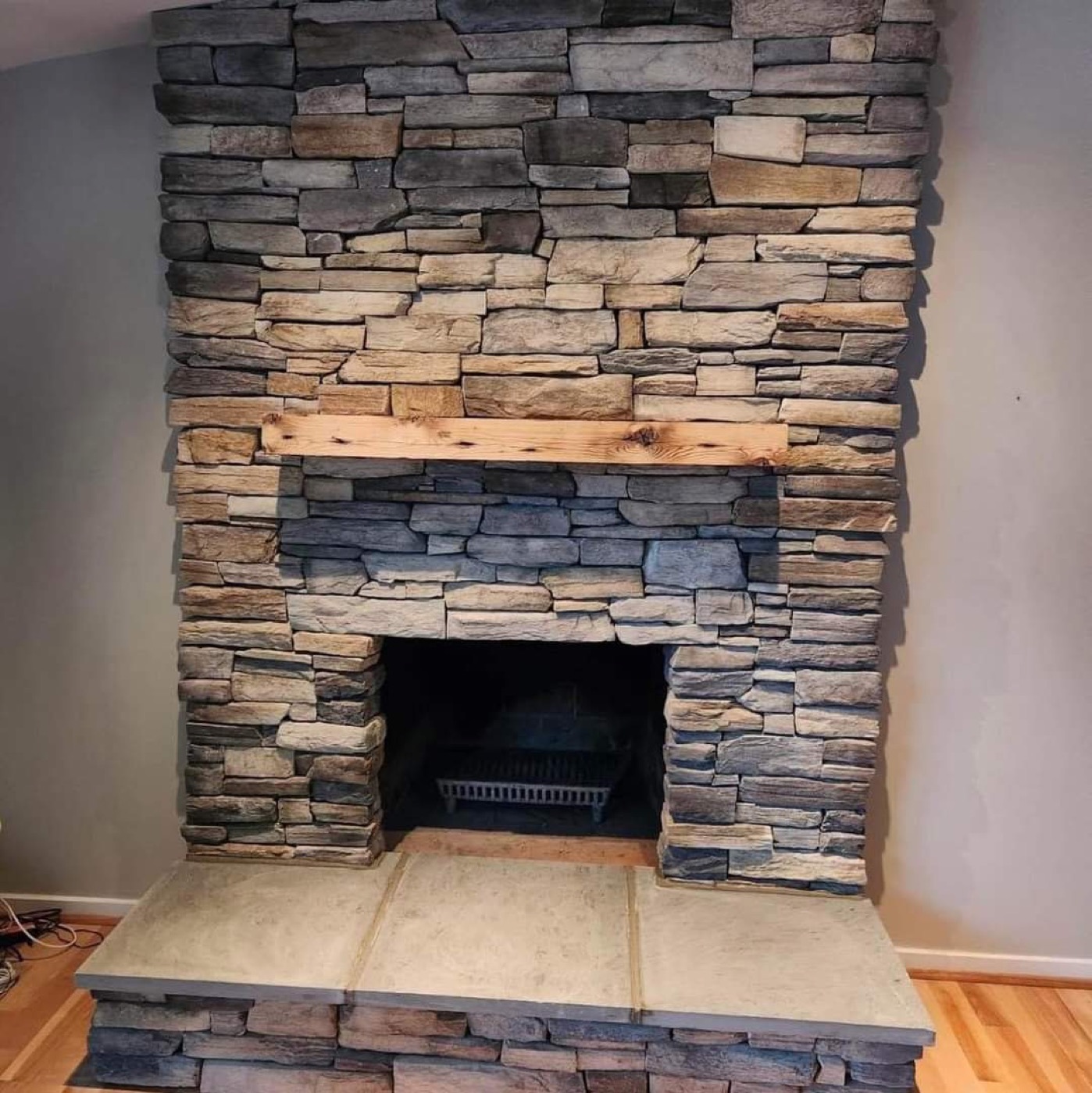 Indoor stone fireplace with wood mantel
