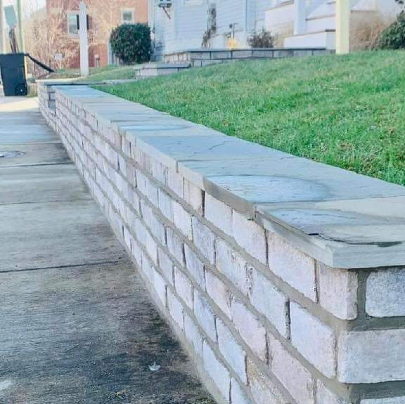 Low curved stone retaining wall with cap stones